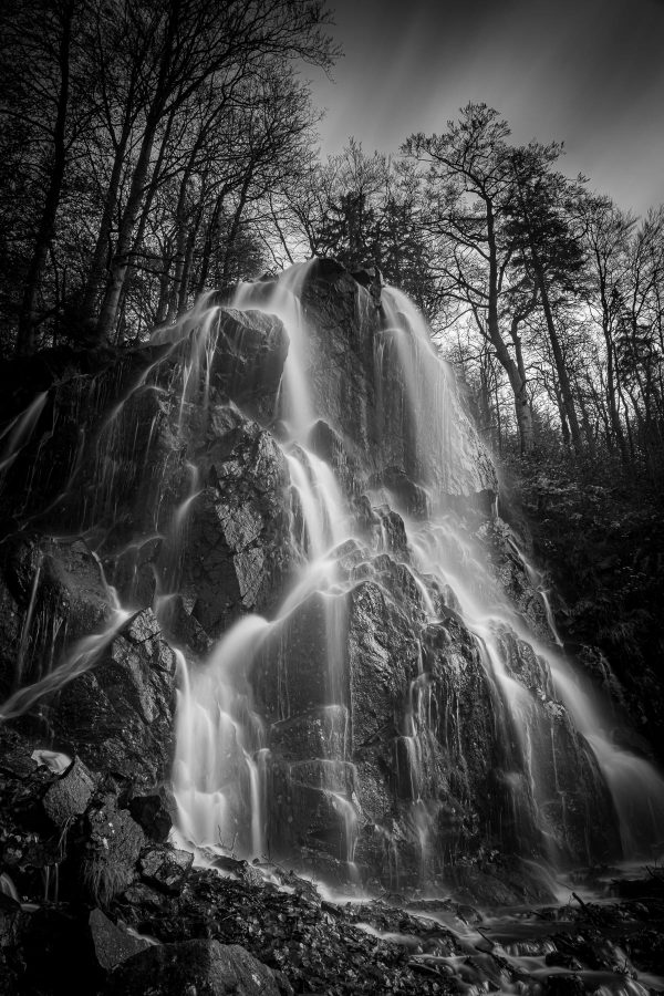 Wasser stürzt einen Wasserfall im Harz hinab.