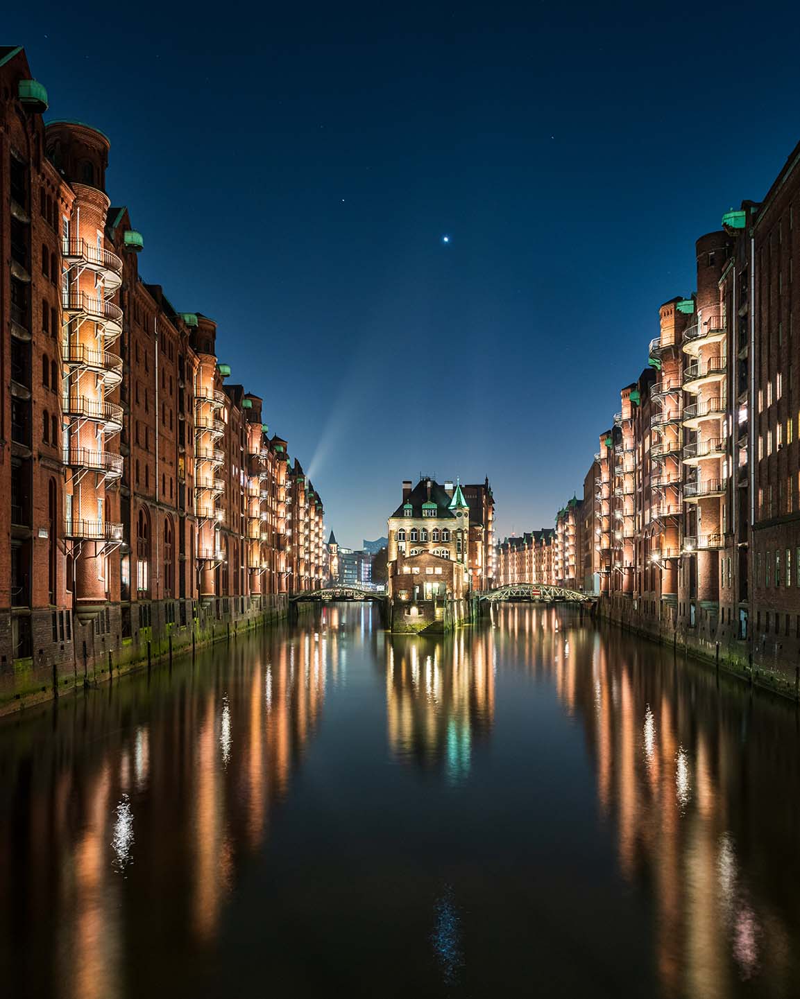 Kanal in der Hamburger Speicherstadt im abendlichen Licht mit Stern am Himmel